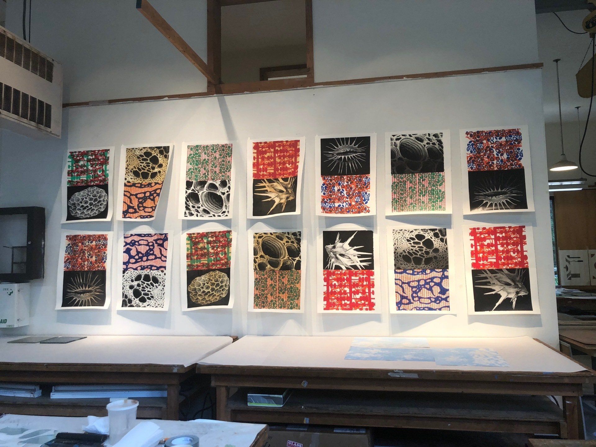 Several paintings are hanging on a wall in a room