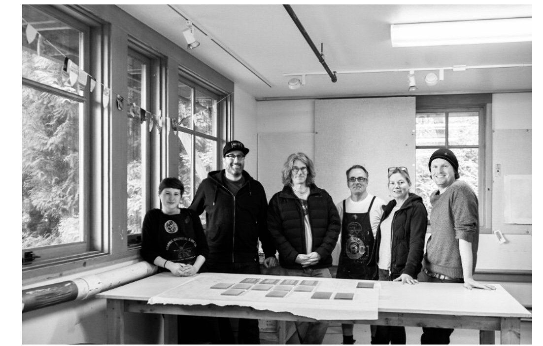 A group of people standing around a table in a room.