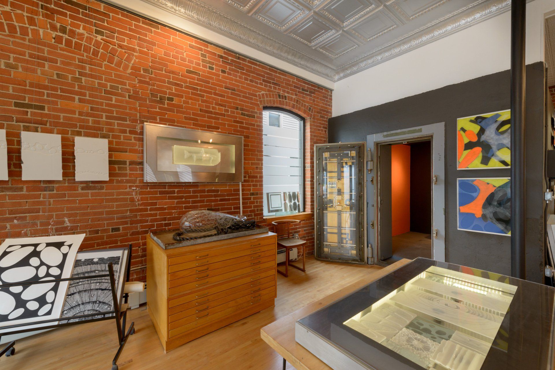 A room with a brick wall and a vaulted door