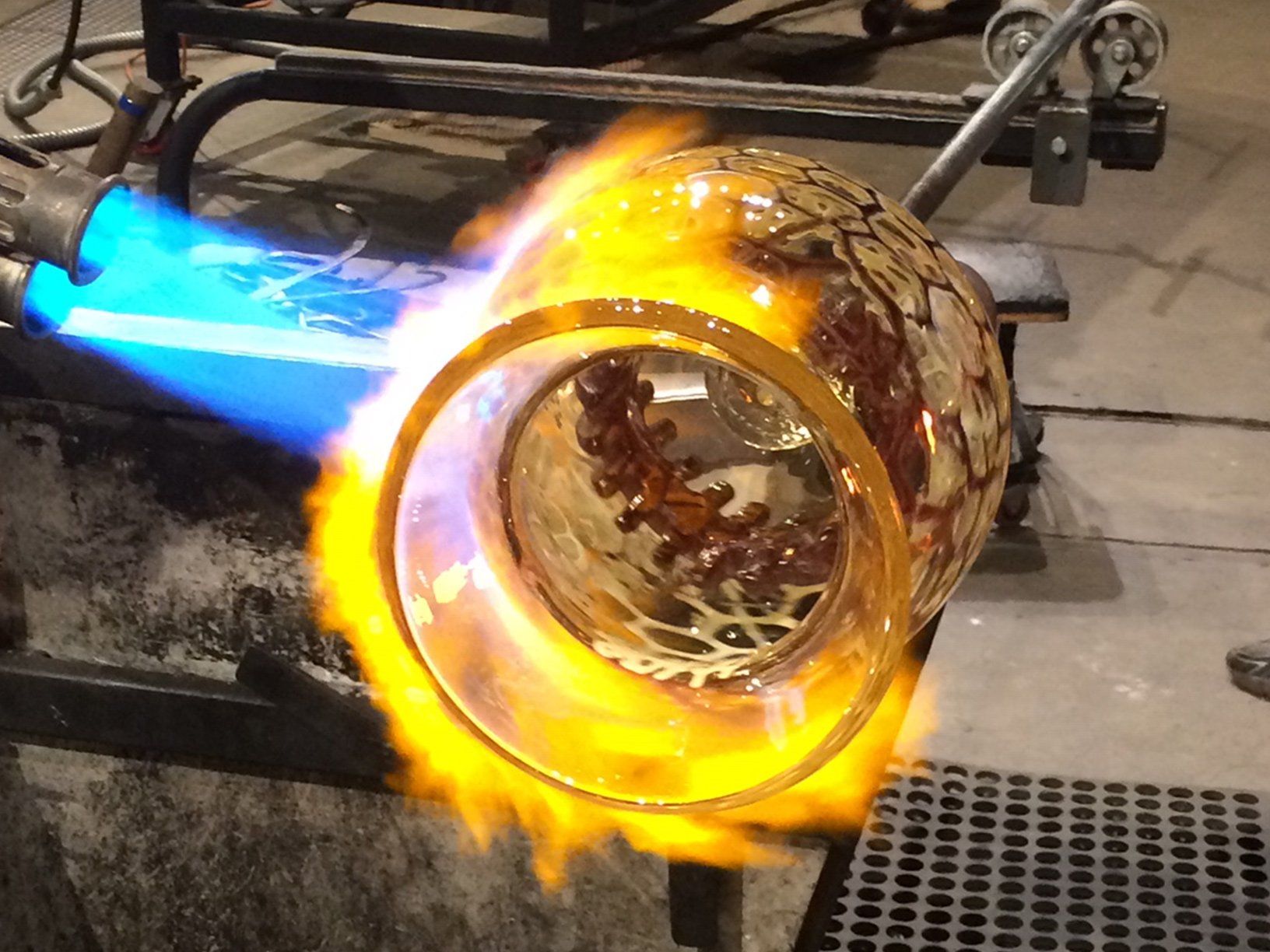 A torch is being used to heat a piece of glass