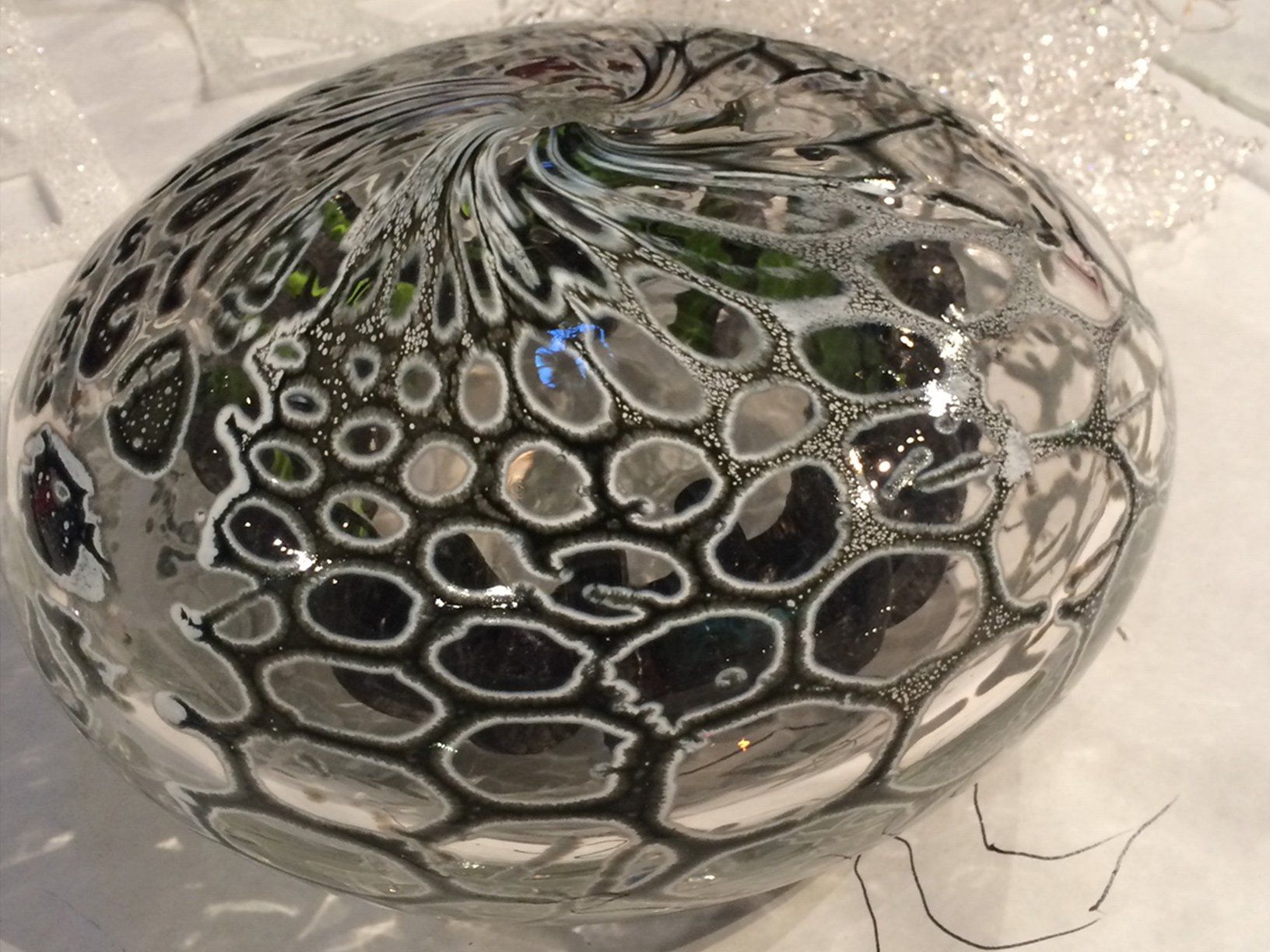 A glass bowl with a black and white pattern on it