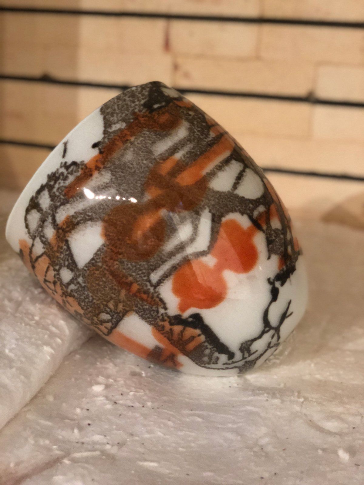 A brown and white vase is sitting on a table