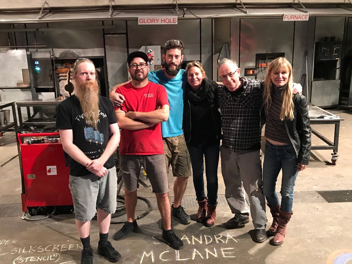 A group of people posing for a picture with the name andra mclane written on the ground