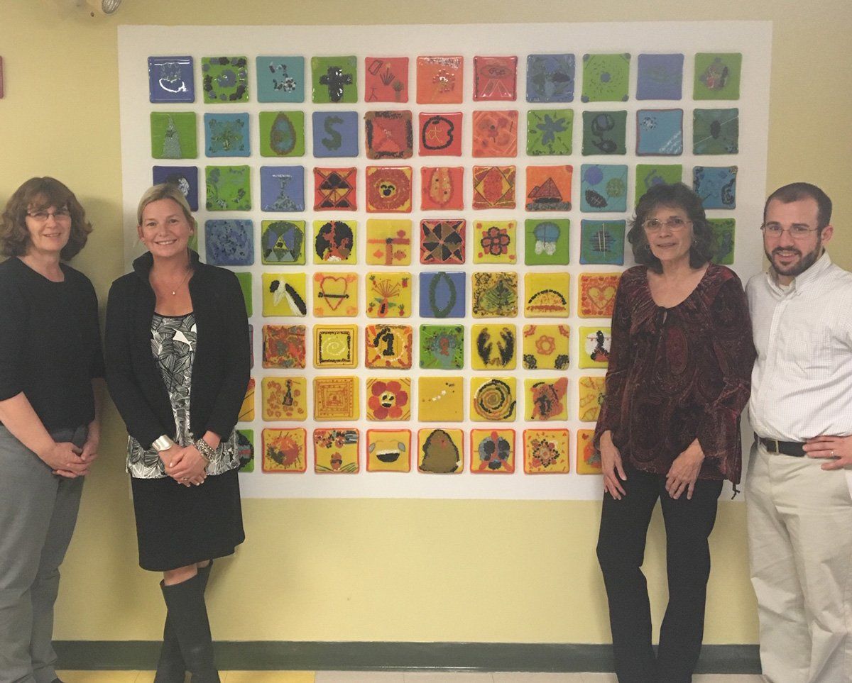 A group of people standing in front of a colorful wall