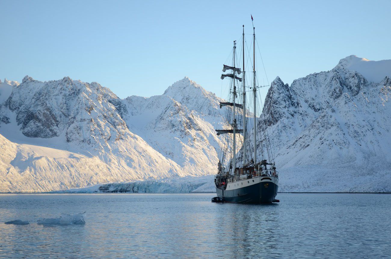 A boat in the water with snowy mountains in the background