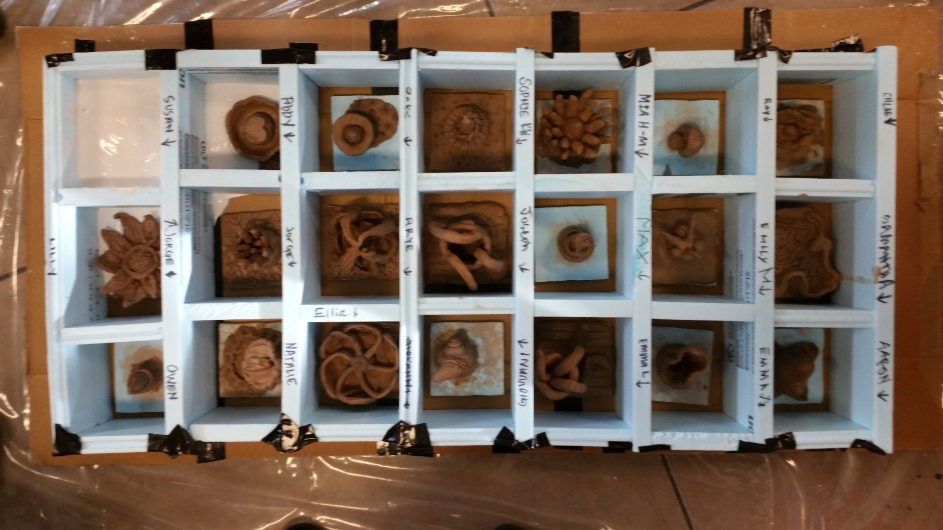 A display case filled with a variety of clay sculptures