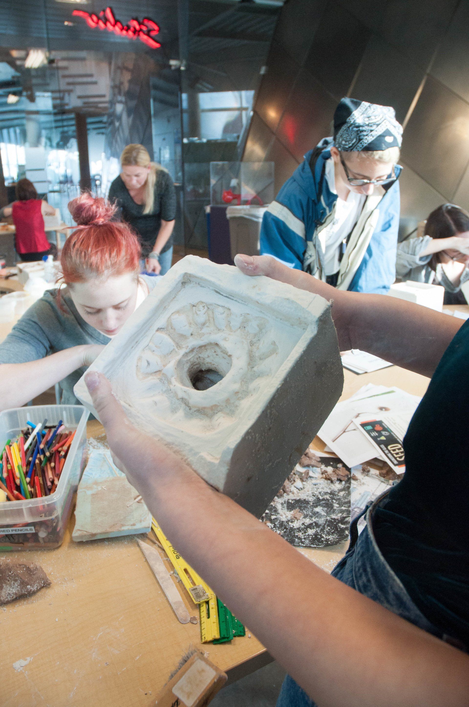 A woman is holding a piece of concrete in her hands