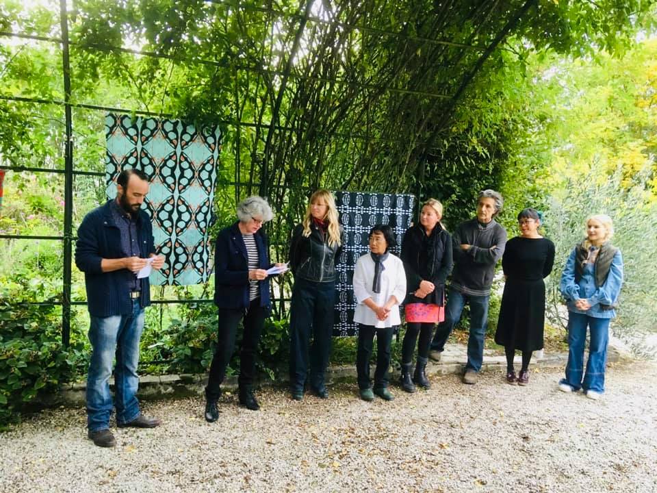 A group of people are standing in front of a fence.