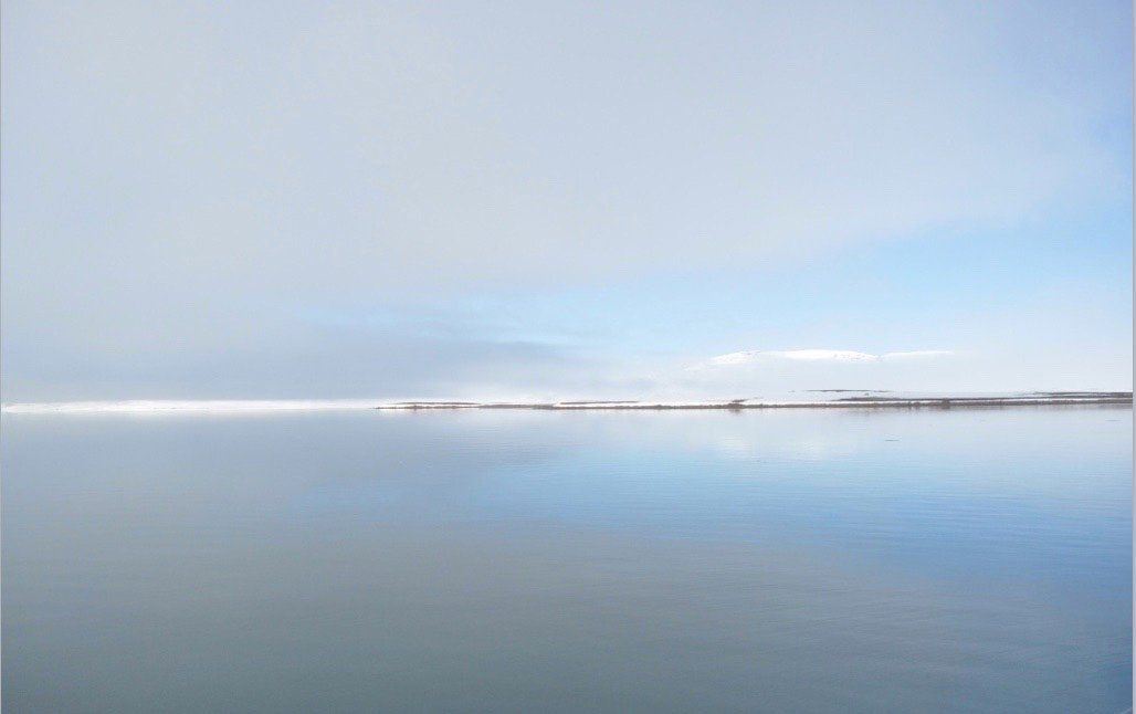 A large body of water with a pier in the distance