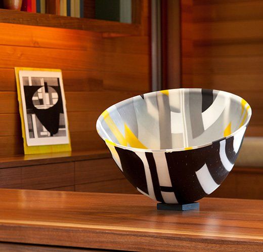 A black white and yellow bowl sits on a wooden table