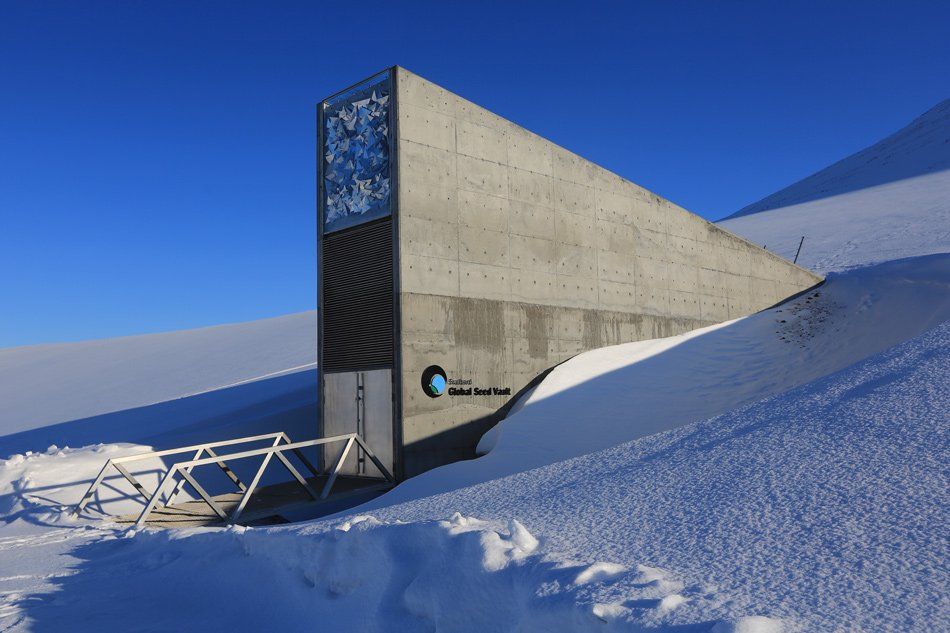 A large concrete building is surrounded by snow