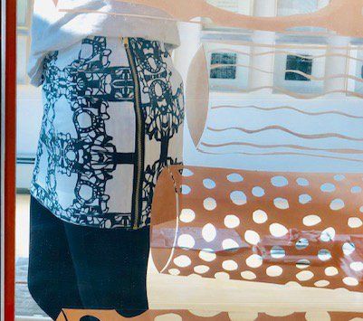 A woman in a polka dot skirt is standing in front of a window