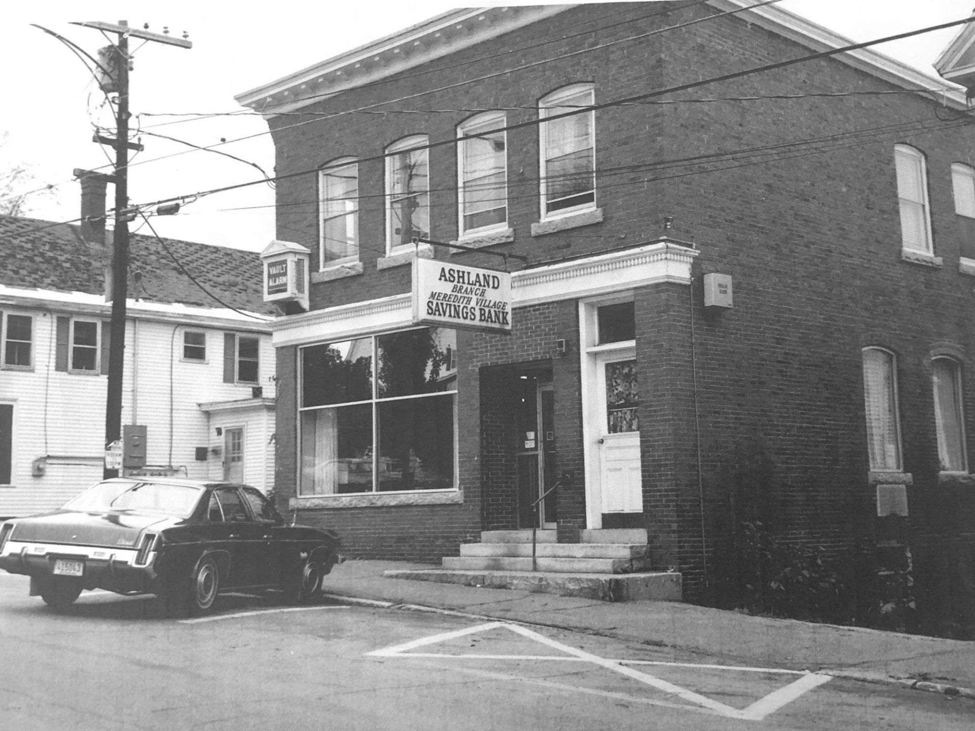A black and white photo of a brick building with a sign that says ' a ' on it