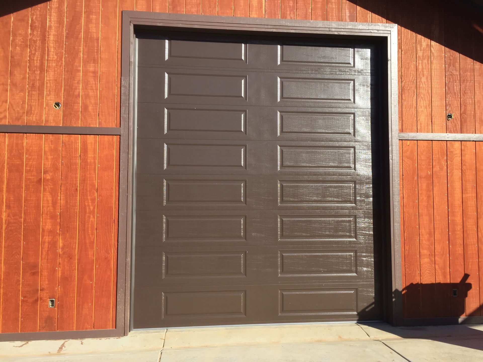 A man is installing an air conditioner on the side of a building.