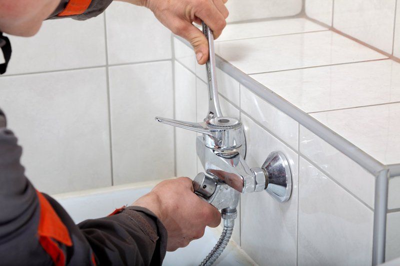 Plumber Hands Fixing Water Tap With Spanner — Dempsey Plumbing in Narara