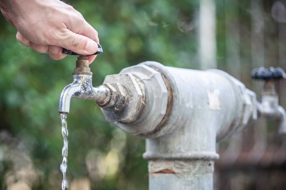 Hand Opens A Water Tap — Dempsey Plumbing In Erina