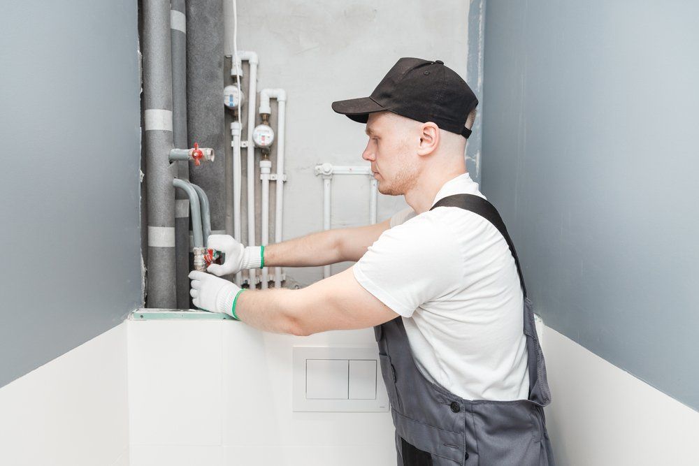 Male Plumber Checks Pipes For Central Hot And Cold Water Supply — Dempsey Plumbing In Cooranbong
