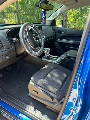 Hand applying ceramic coating on a red car with a black applicator.