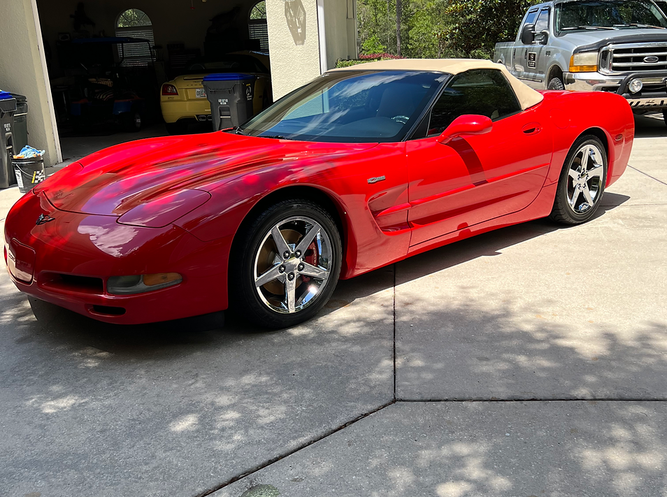 Person wearing black gloves applying ceramic coating to a car's hood.