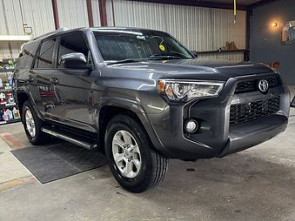 Person wearing black gloves applying ceramic coating to a car's hood.