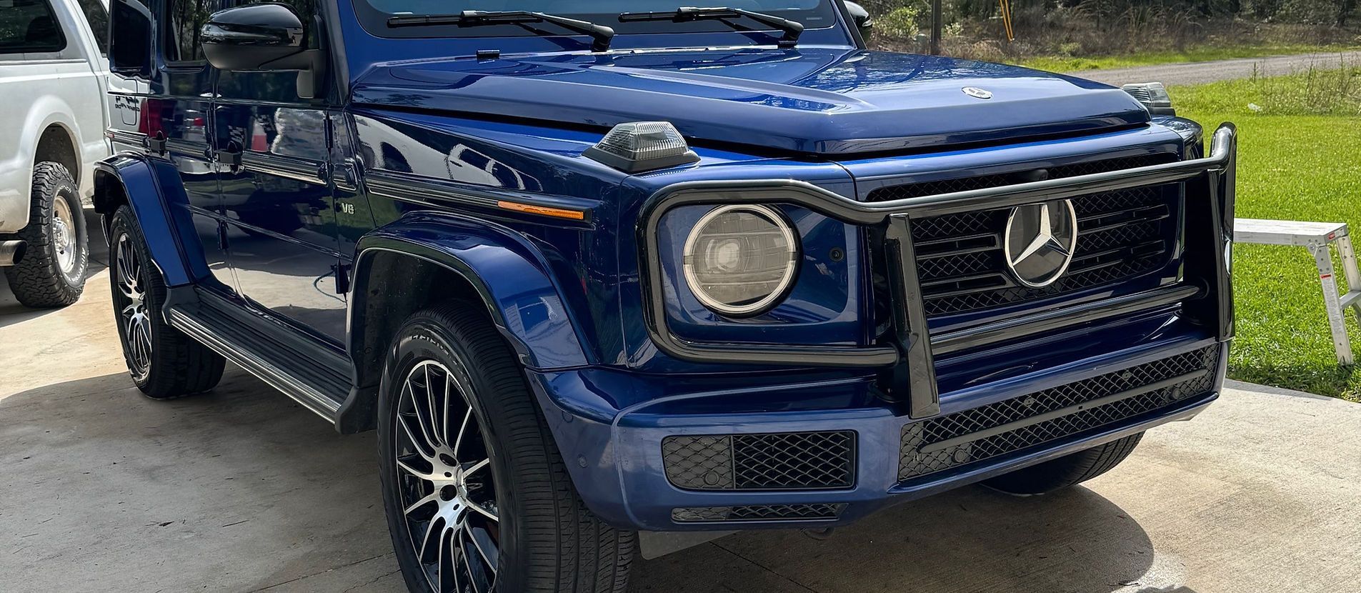 Hand applying ceramic coating on a red car with a black applicator.