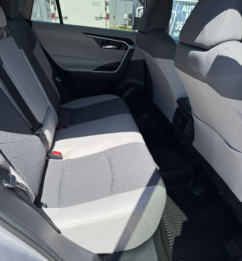 Back interior of a gray car with light gray and dark gray seats.