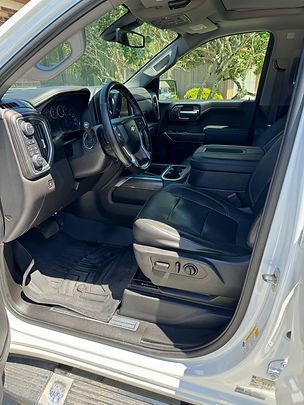 Hand applying ceramic coating on a red car with a black applicator.