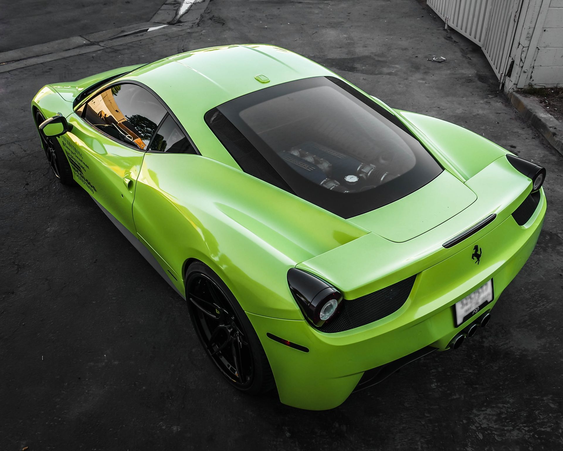 Gray Lamborghini sports car parked next to a white wall.