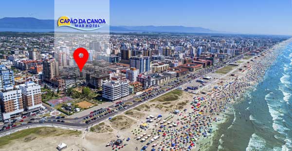 Uma vista aérea de uma cidade com uma praia em primeiro plano.