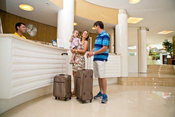 Um homem e uma mulher estão no saguão de um hotel com suas bagagens.