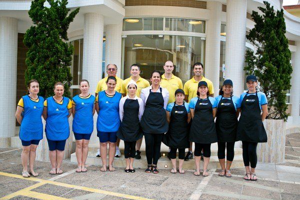 Um grupo de pessoas posando para uma foto em frente a um prédio