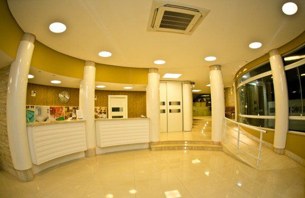 Uma grande sala com colunas e ventilador de teto