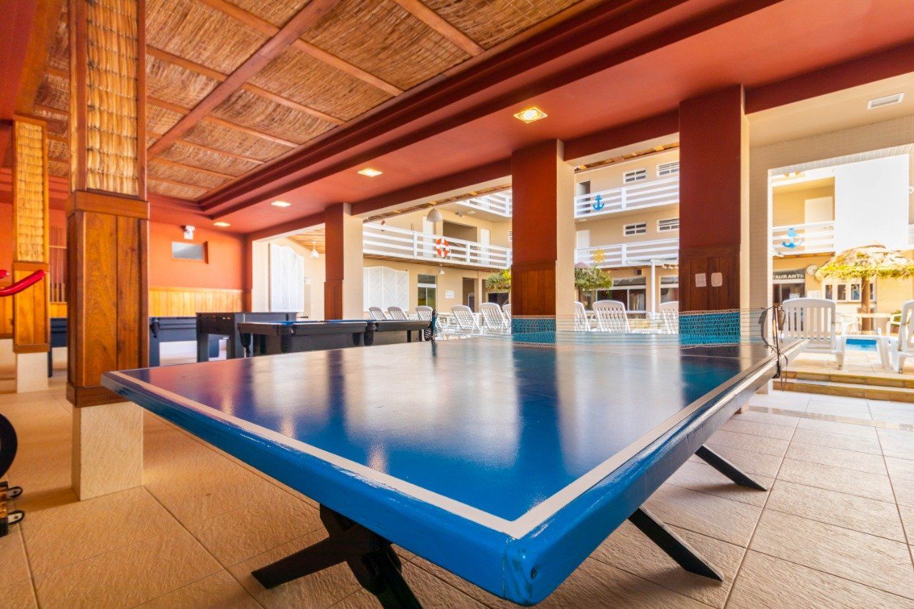 Há uma mesa de pingue-pongue azul no meio de uma sala.