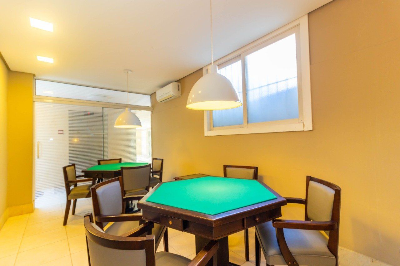 Uma sala de jogos com mesa e cadeiras verdes