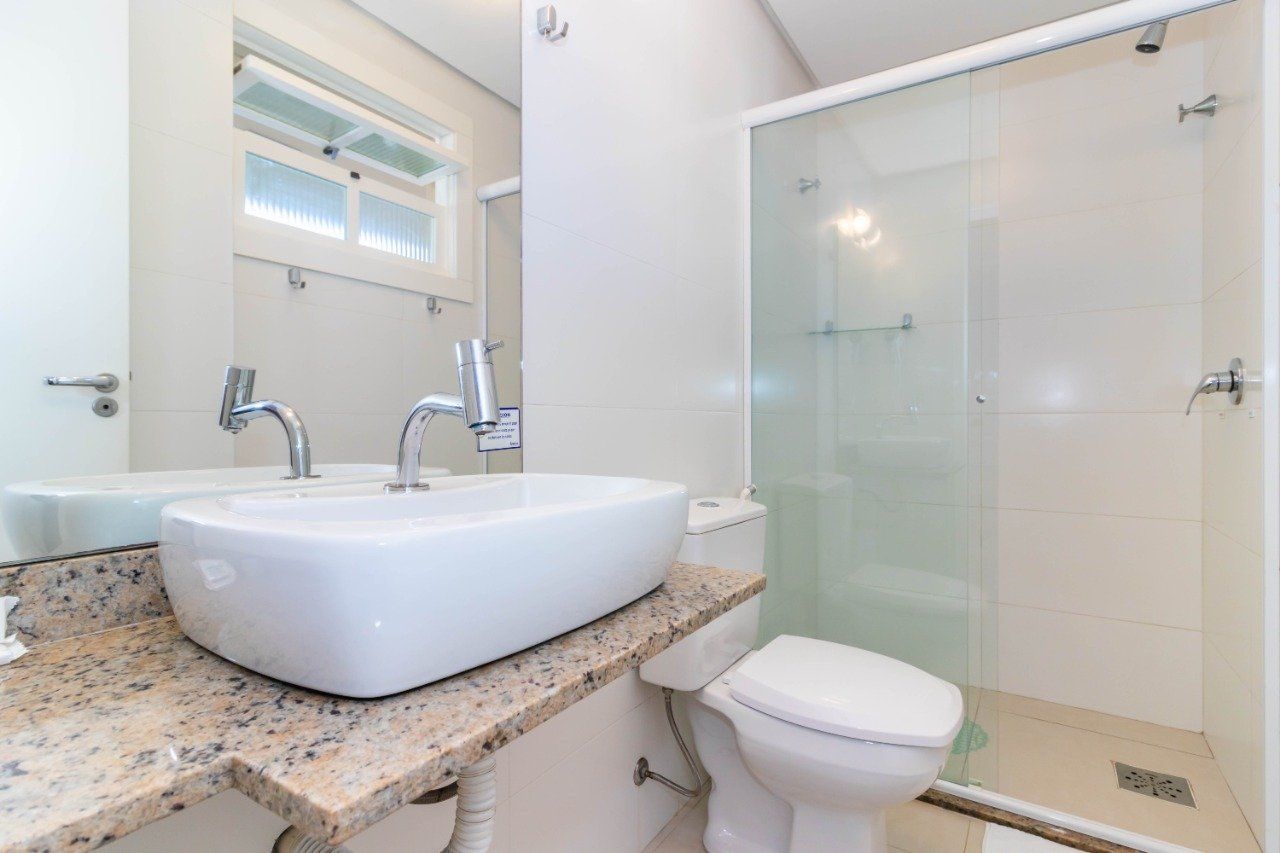 Um banheiro com pia, vaso sanitário e chuveiro.