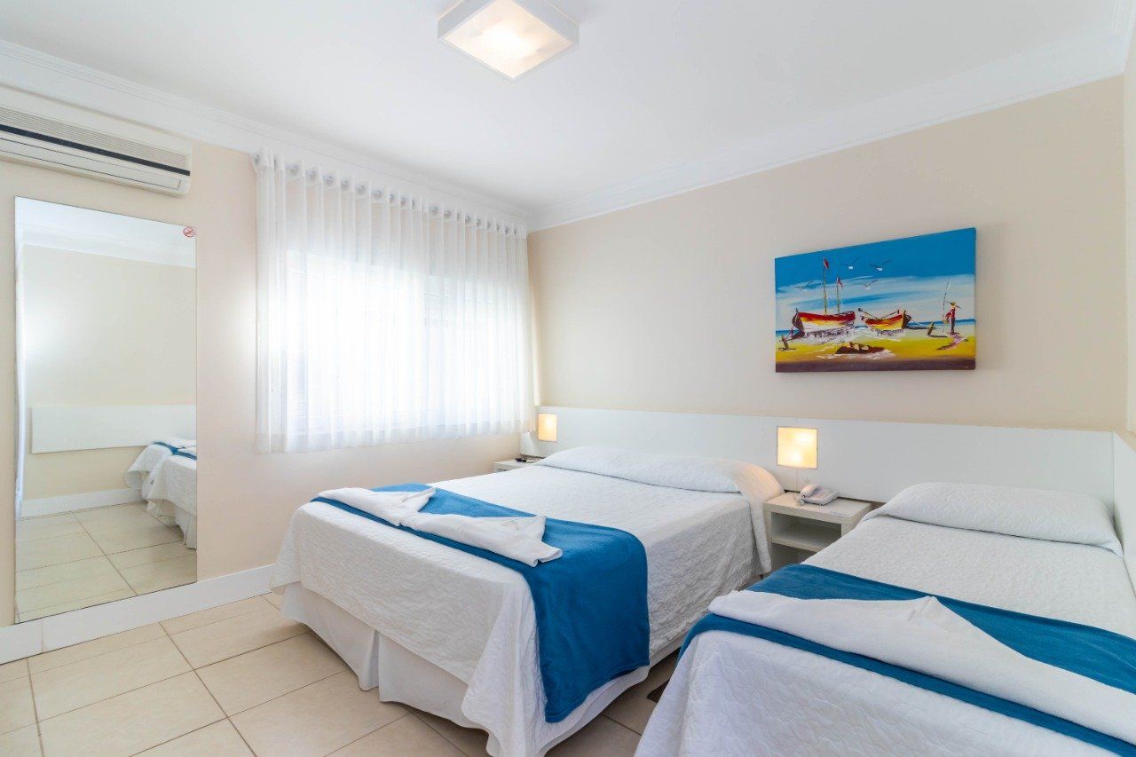 Um quarto de hotel com duas camas e uma pintura na parede