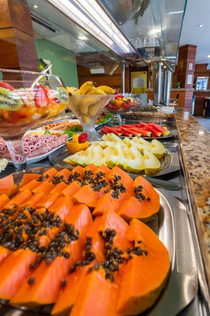 Uma variedade de frutas e vegetais são exibidos em uma mesa de bufê.