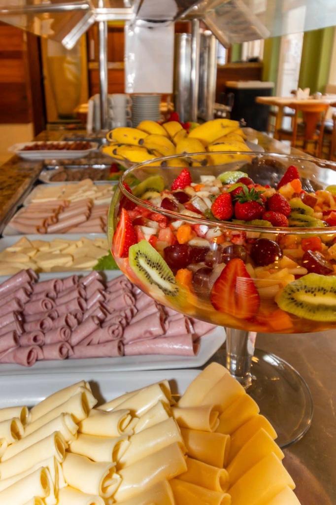 Uma mesa de buffet com uma variedade de alimentos, incluindo frutas e queijos