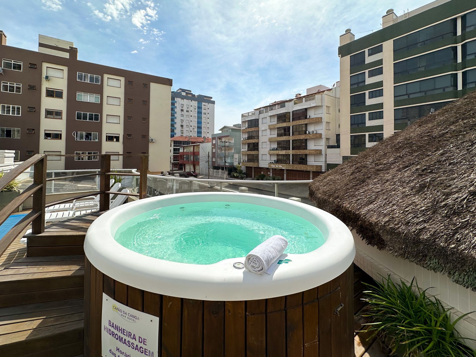 Uma banheira de hidromassagem está no topo de um deck de madeira.