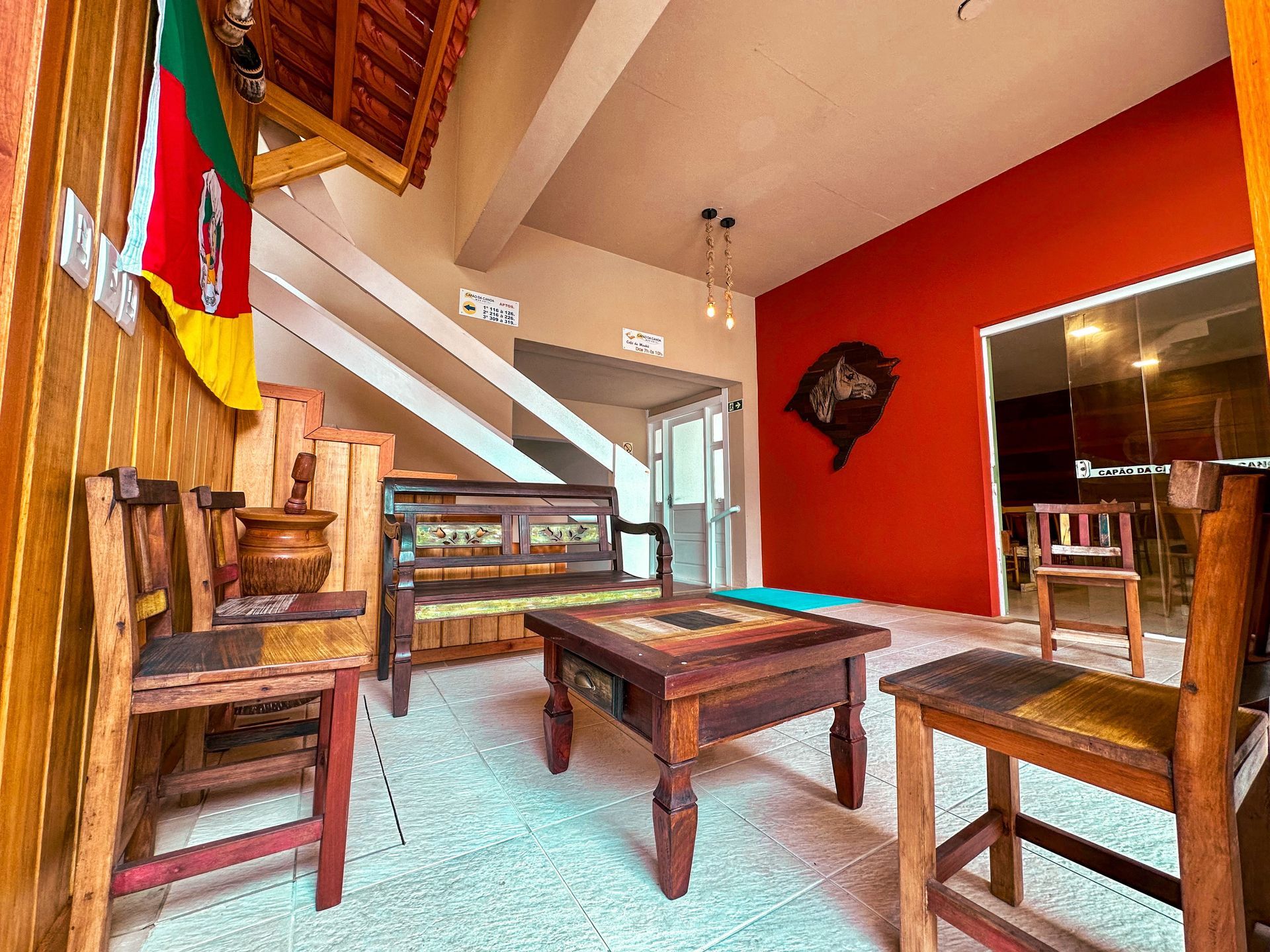 Uma sala de estar com mesa e cadeiras de madeira e parede vermelha.