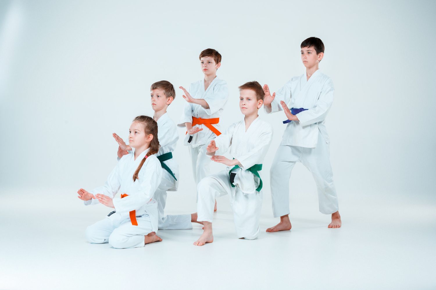 A group of children are practicing karate in a gym.