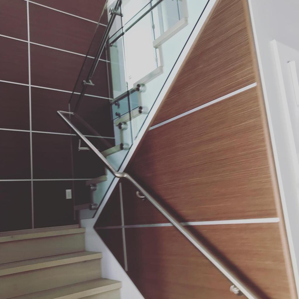 A staircase with a glass railing and a wooden wall