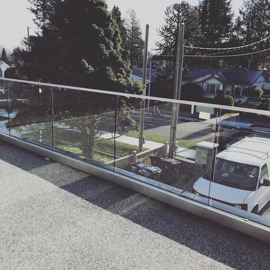 A white van is parked in front of a glass railing