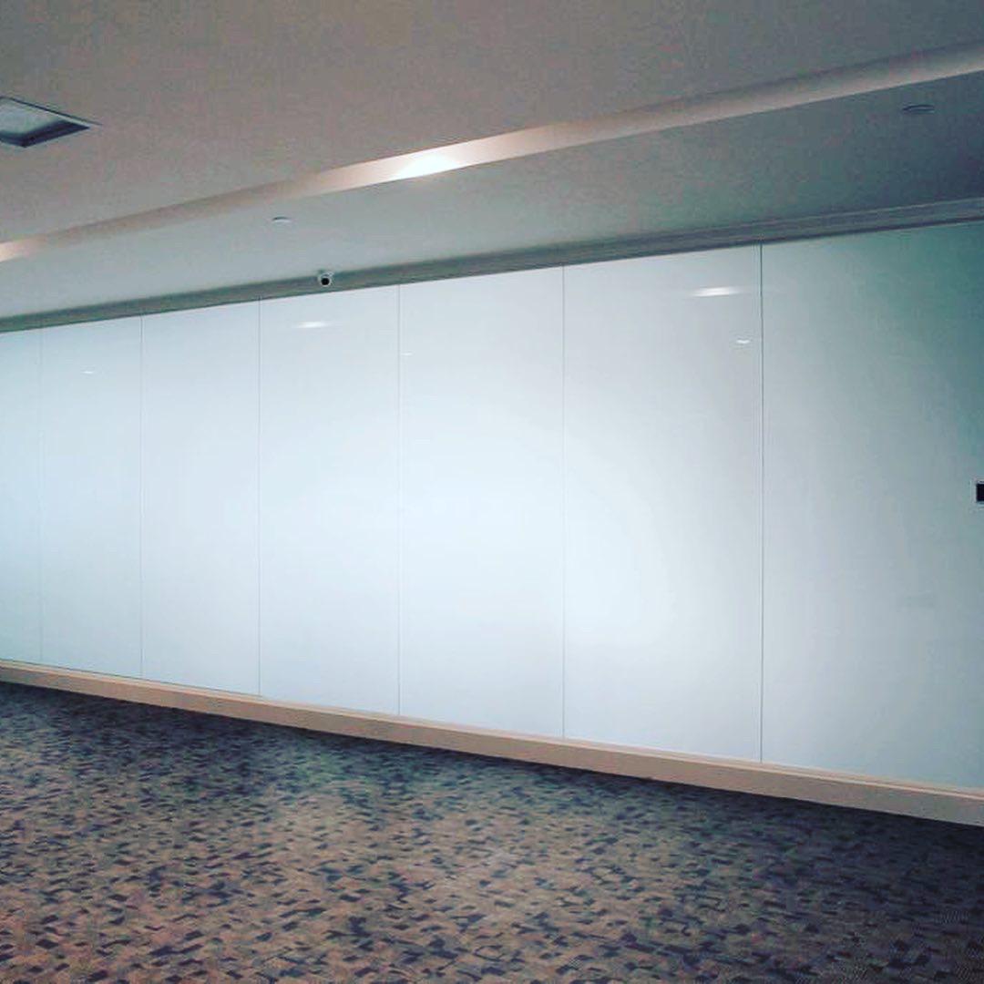 There is a large white wall in the middle of the room.