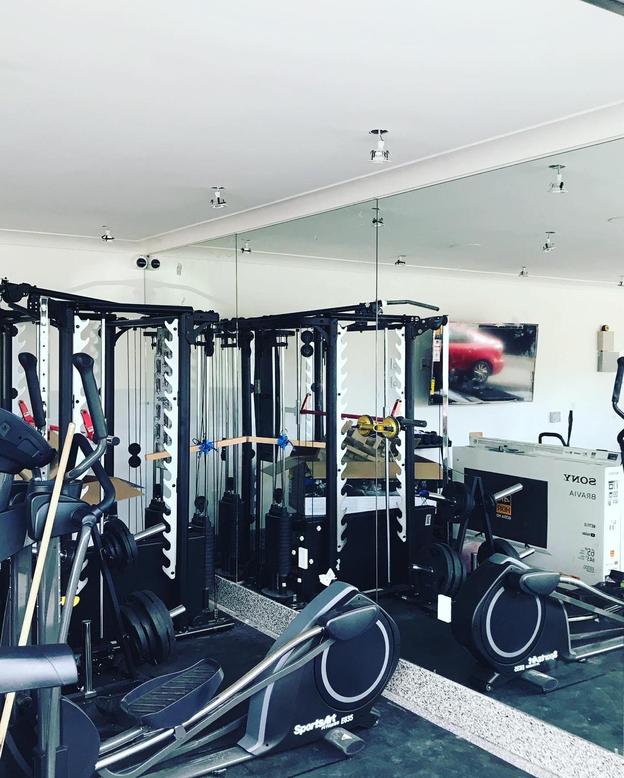 A gym with a lot of equipment and a picture of a car on the wall