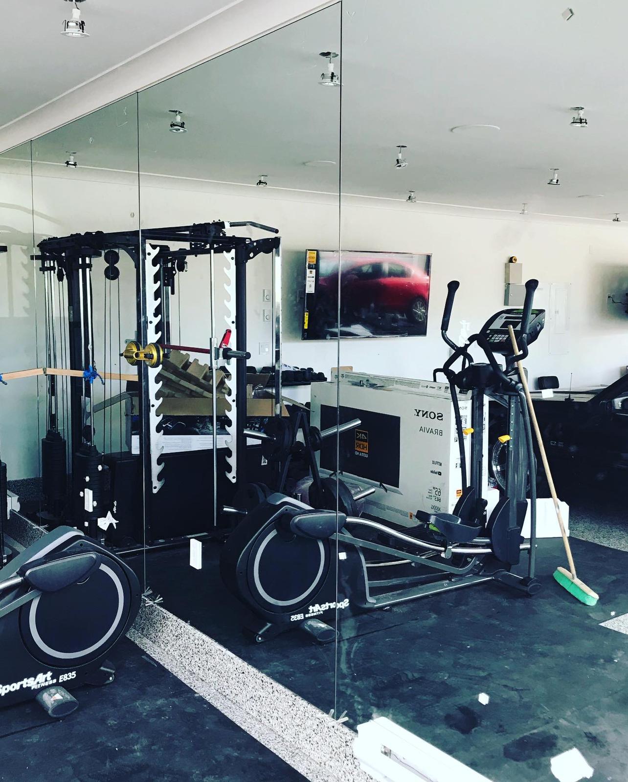 A gym with a lot of equipment and a large mirror