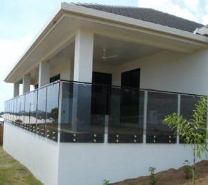 A white house with a glass railing on the porch