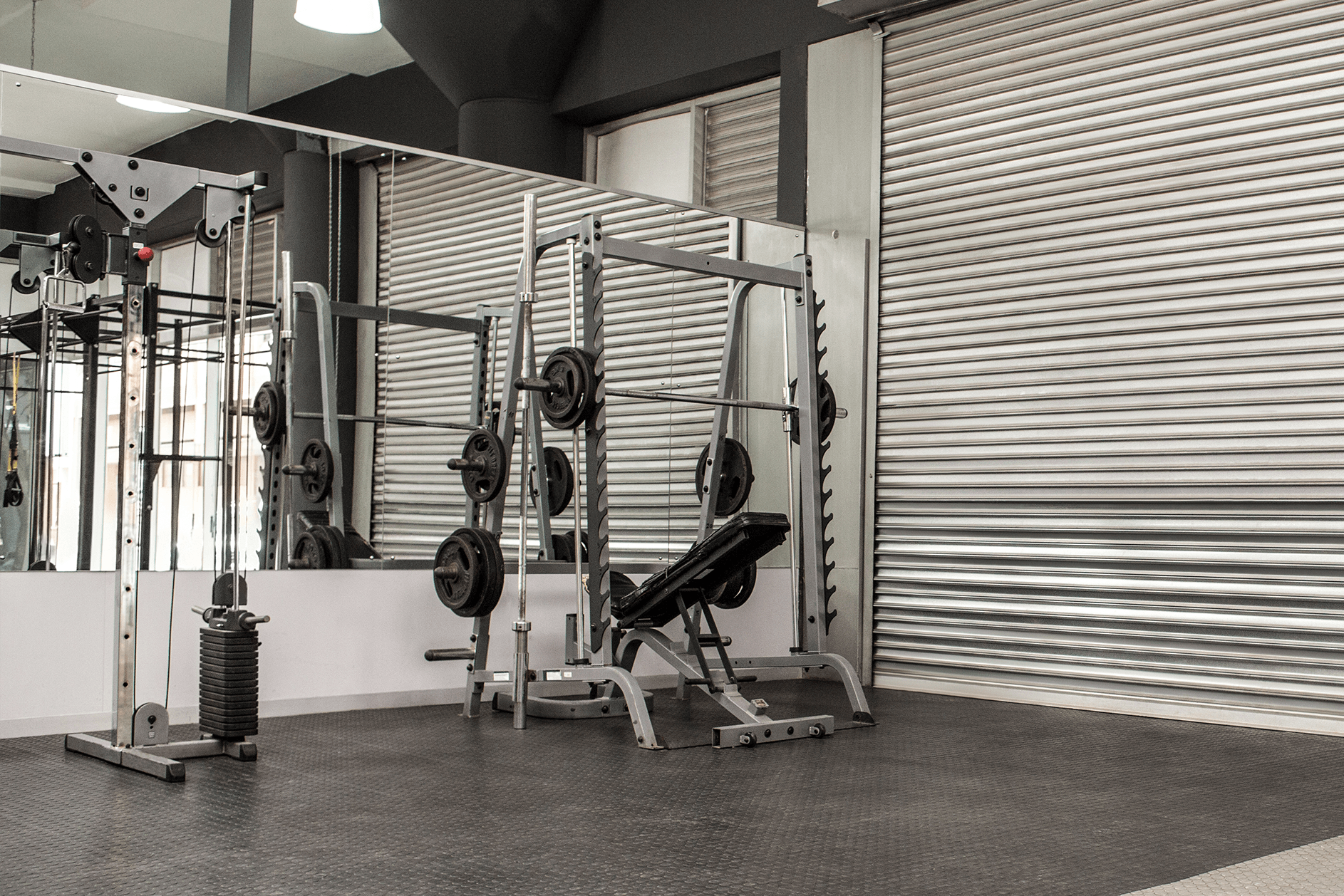 A gym with a lot of equipment and a large mirror