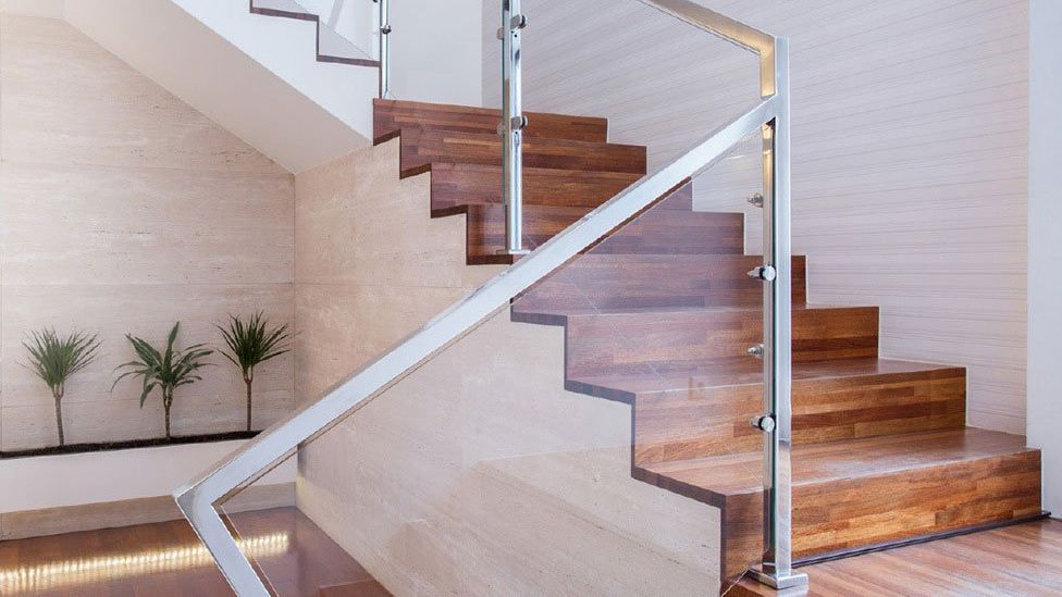 A staircase with wooden steps and a glass railing.