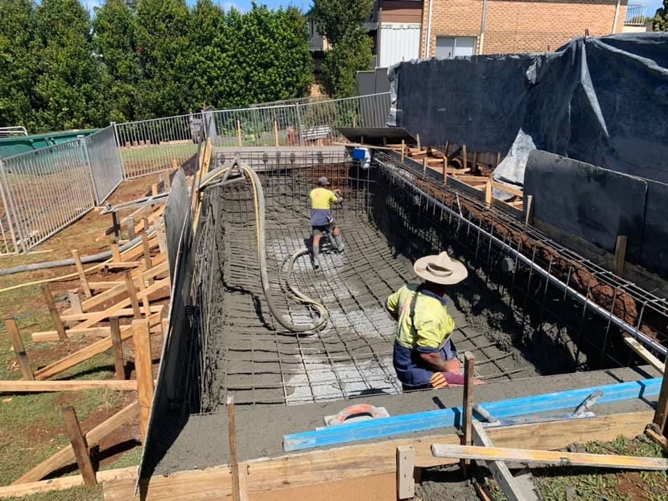 Construction Workers Pouring Concrete Into a Rectangular Pool Form — Banora Pools in Tweed Heads South, NSW